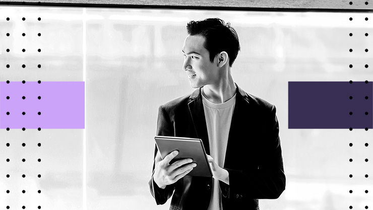 A man holding a tablet and looking out a window