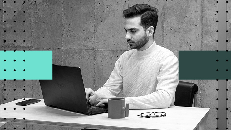 A man sitting at a table using a laptop