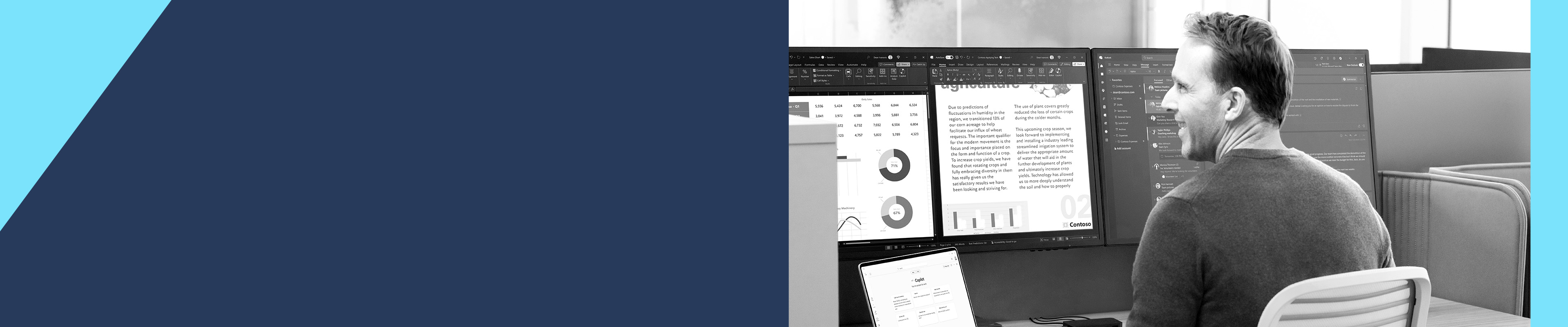 A man sitting at a desk in front of multiple computer monitors using a laptop